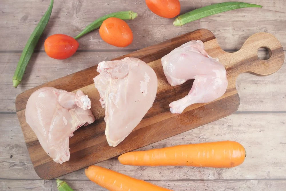Real photograph of raw chicken portions on a cutting board